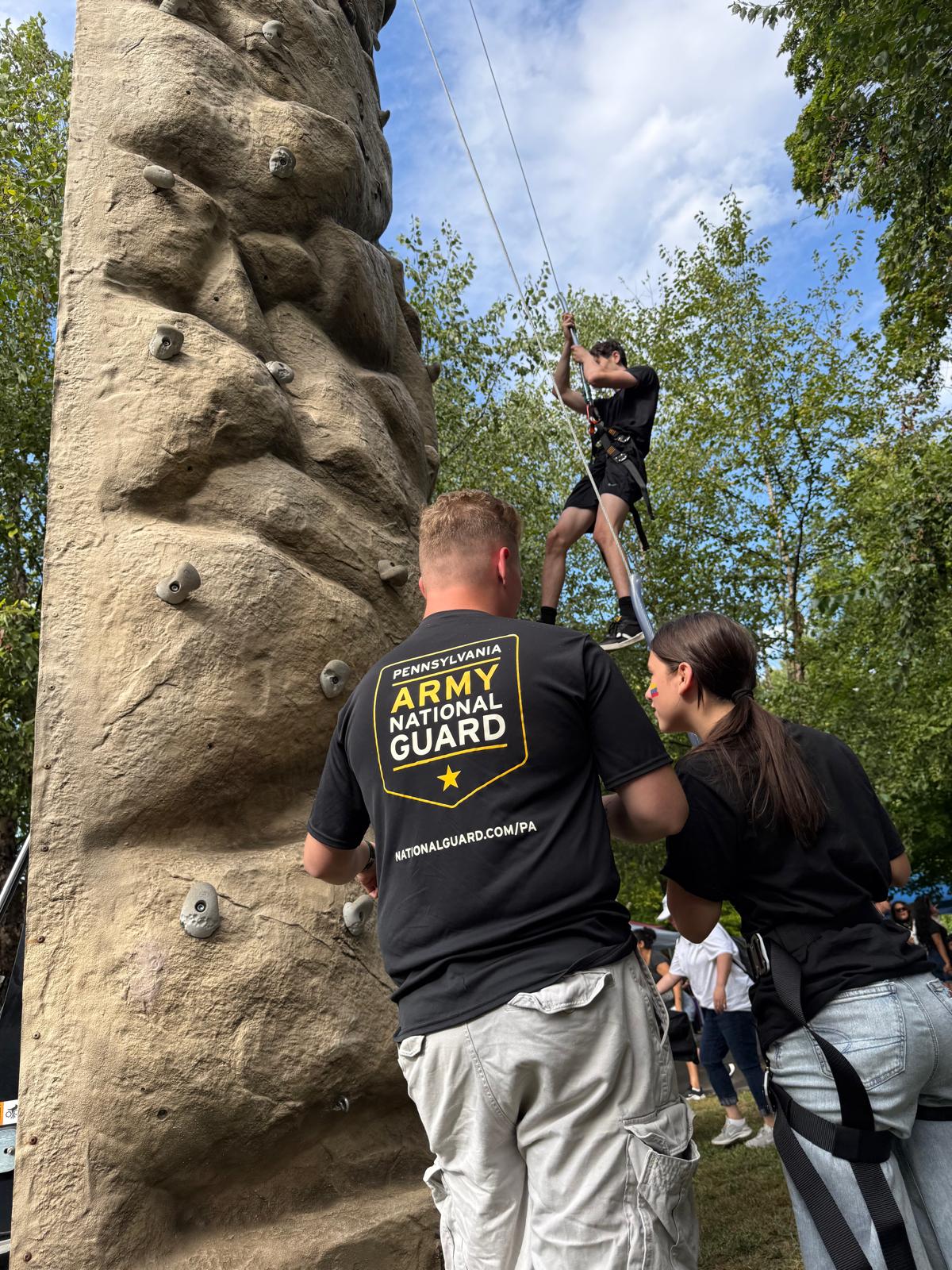 Festival guest trying the Army National Guard climbing wall